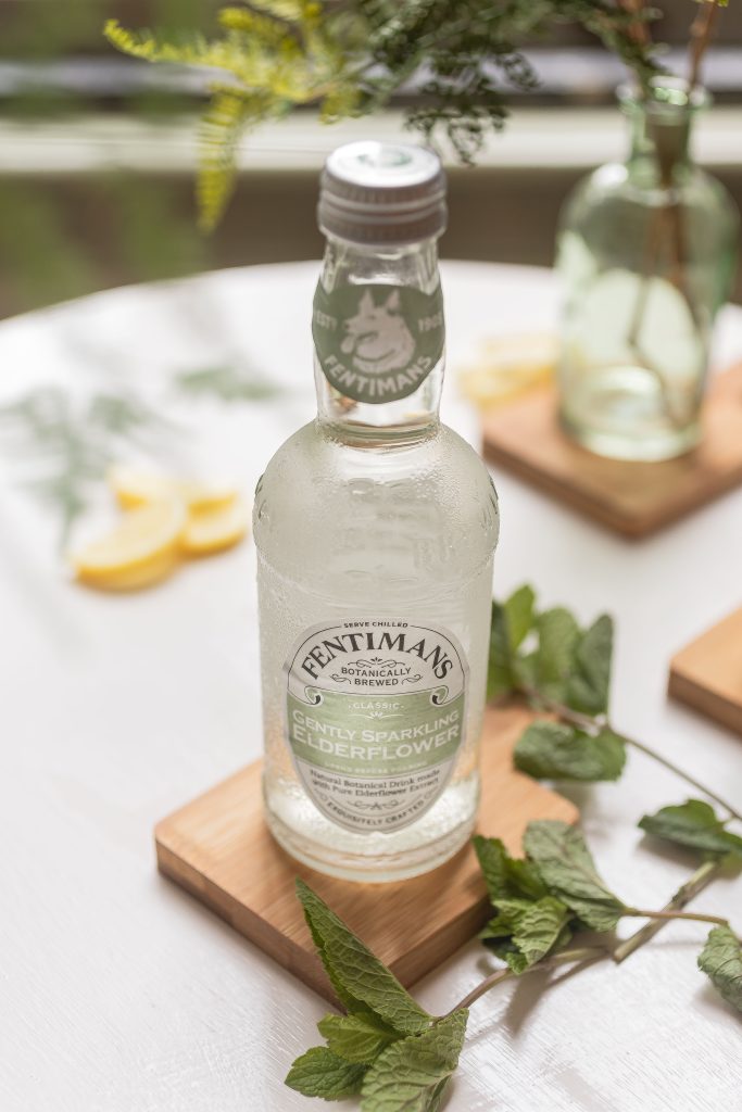 Refreshing Fentimans elderflower soda served with fresh mint leaves and lemon slices. Soda Fentimans à la fleur de sureau rafraîchissant servie avec des feuilles de menthe fraîche et des tranches de citron.