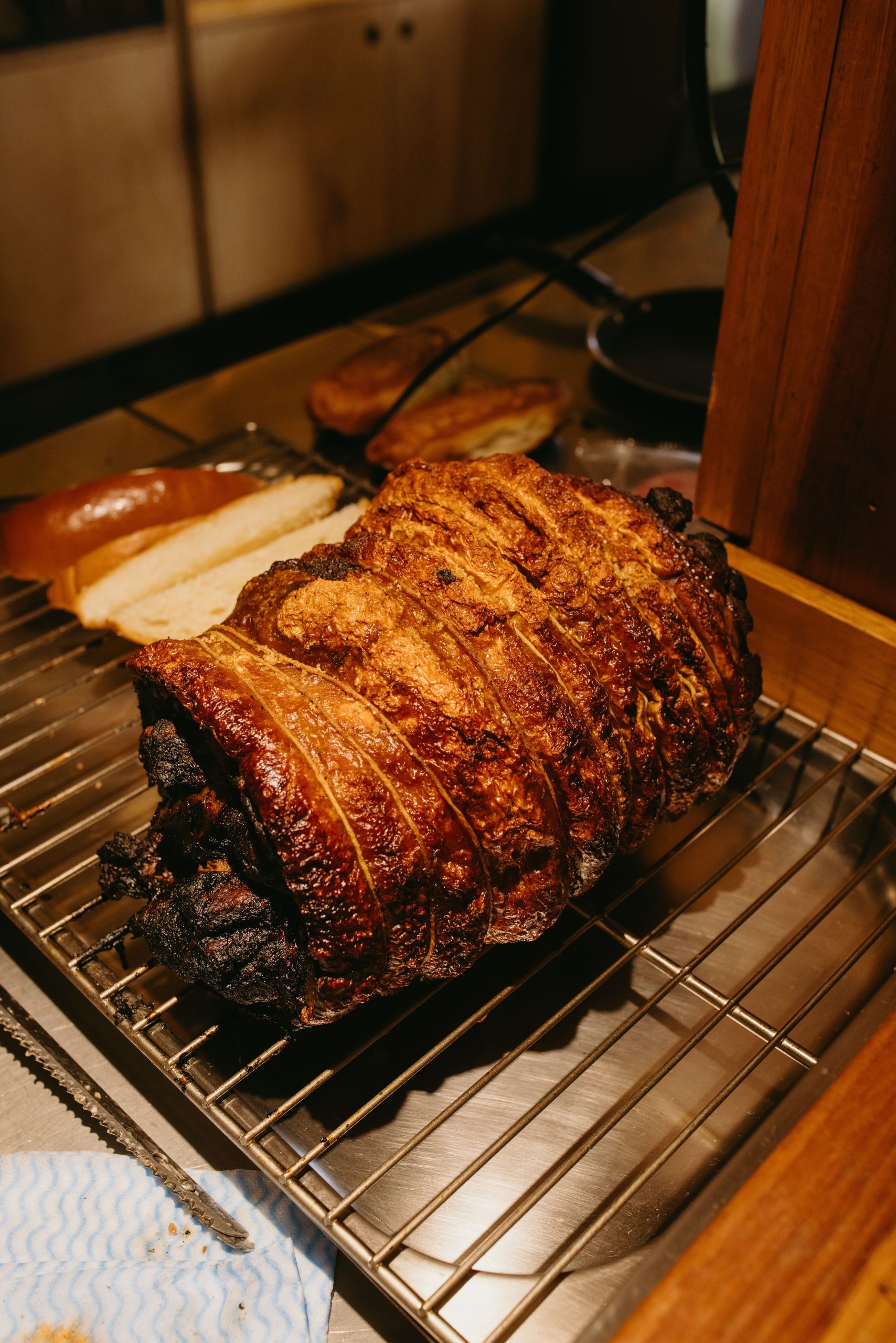 Deliciously roasted pork with a crispy crust, resting on a kitchen rack, perfect for culinary presentations. Du porc rôti délicieusement avec une croûte croustillante, reposant sur un support de cuisine, parfait pour les présentations culinaires.