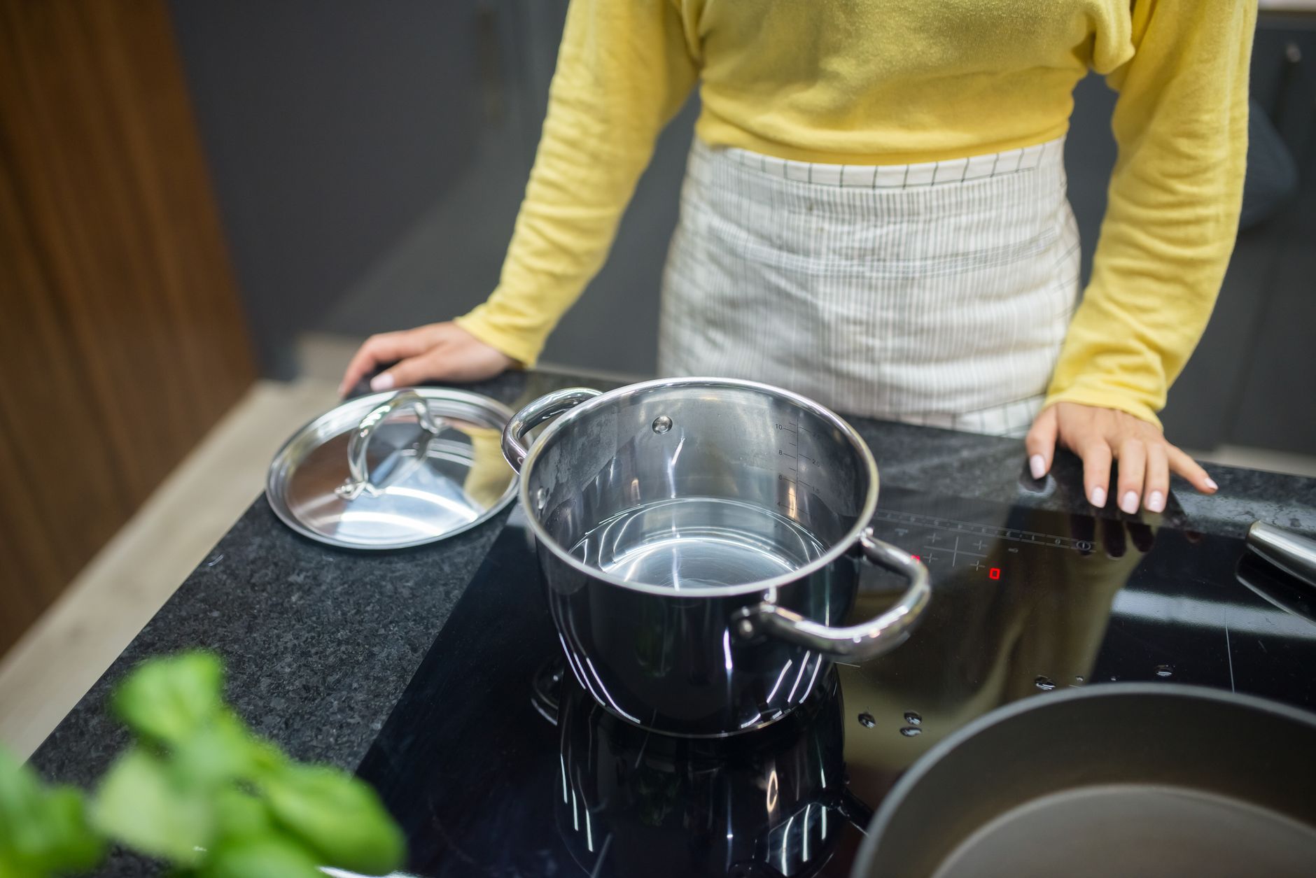 Personne cuisinant sur une plaque à induction avec une casserole