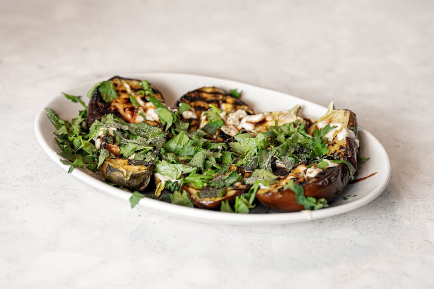 Aubergines rôties aux herbes dans un plat ovale