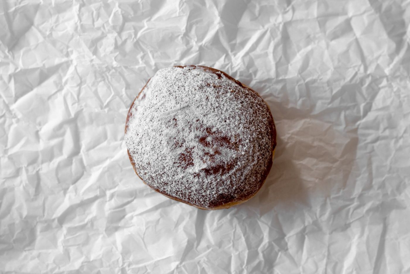Beignet saupoudré de sucre glace sur papier froissé