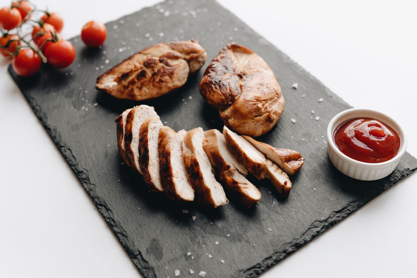 Blancs de poulet grillés et tranchés sur une ardoise