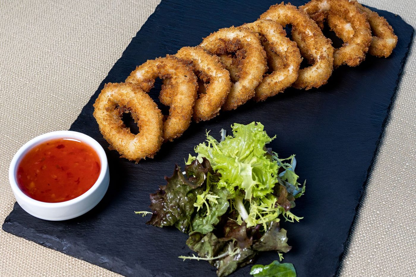 Anneaux de calamars panés sur ardoise, sauce chili
