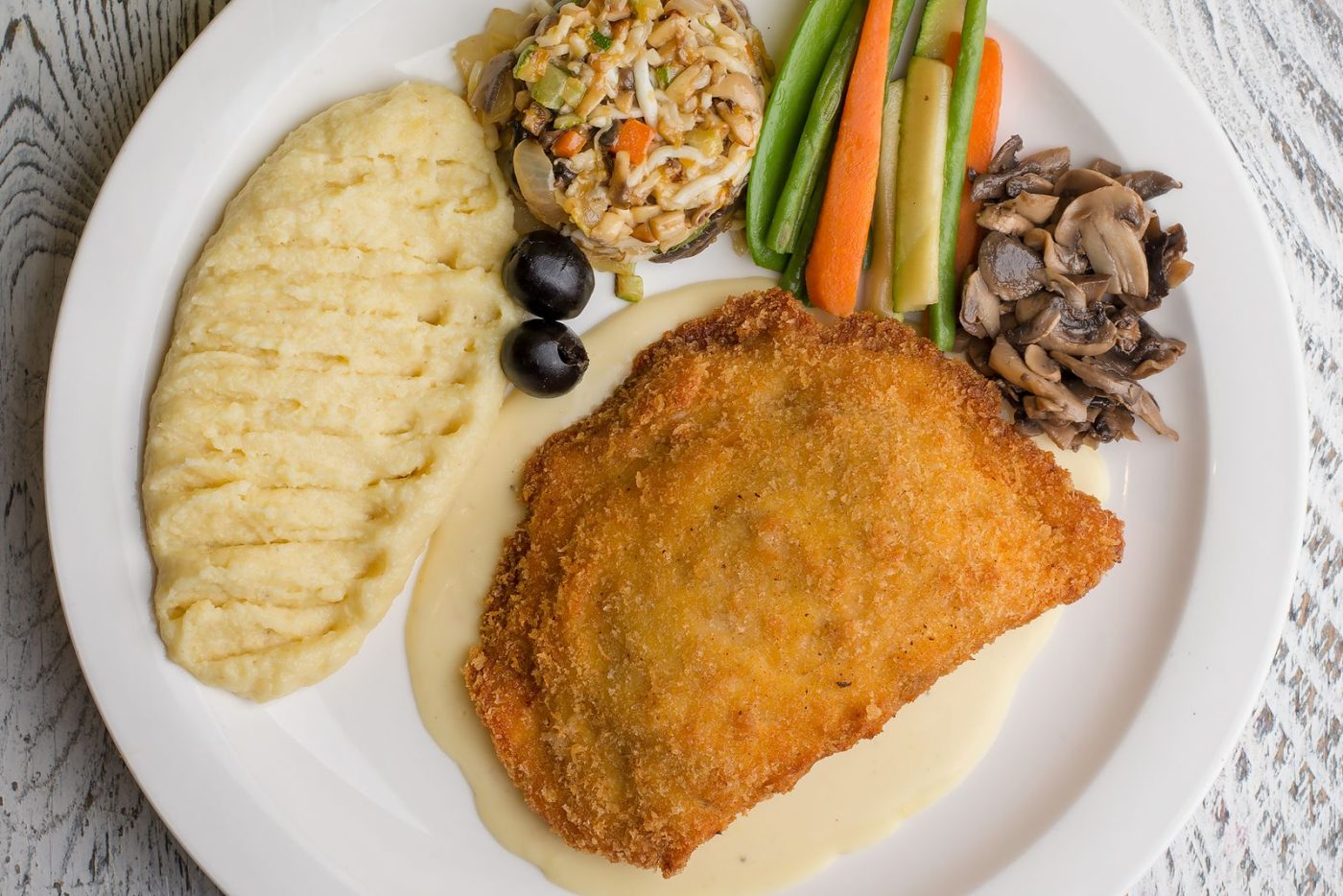 Cordon bleu pané servi avec purée et légumes