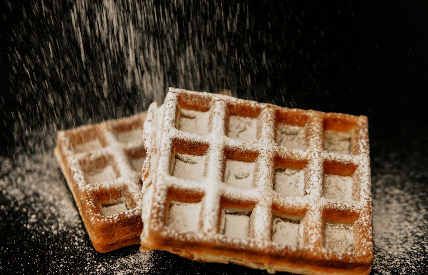 Gaufres saupoudrées de sucre glace sur fond sombre