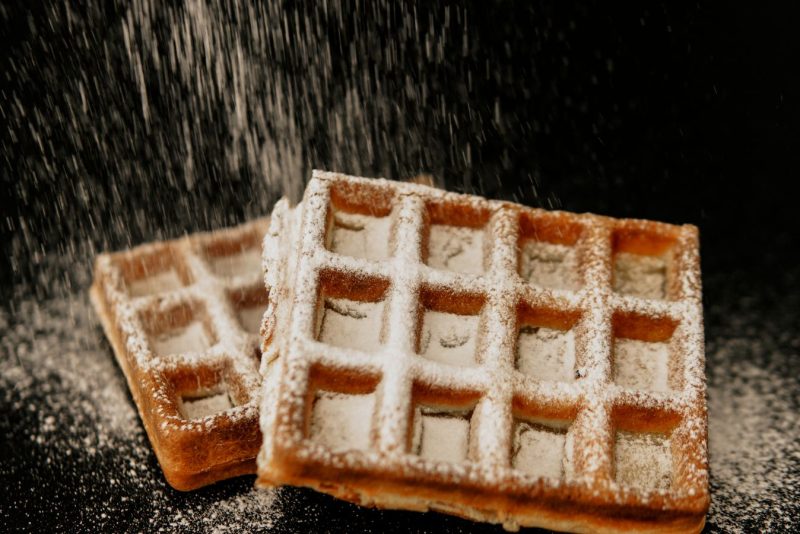 Gaufres saupoudrées de sucre glace sur fond sombre