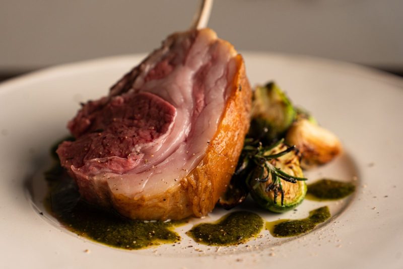 Gigot d'agneau rosé tranché, sauce aux herbes