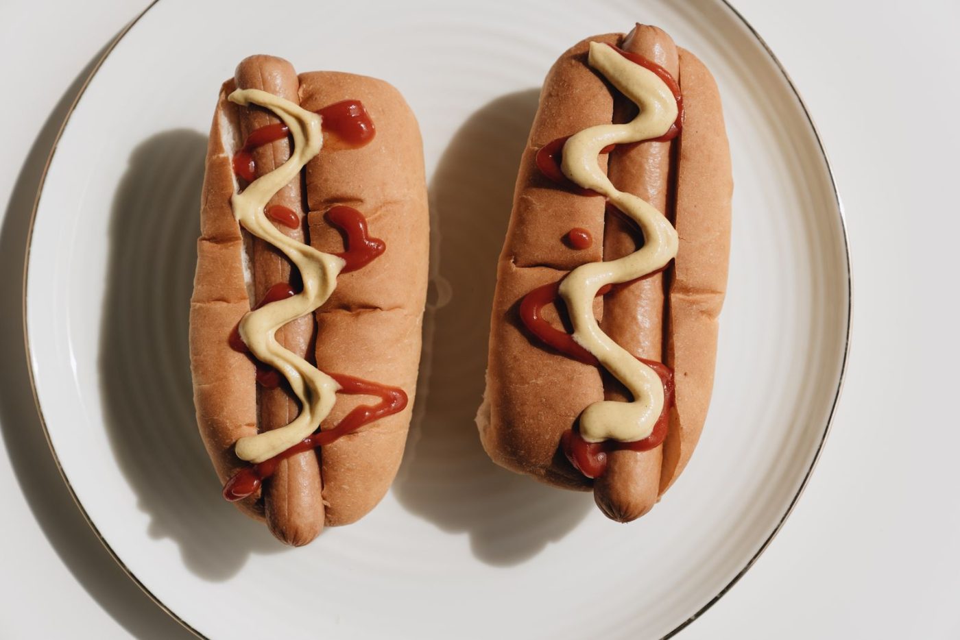Deux hot-dogs nappés de ketchup et de moutarde