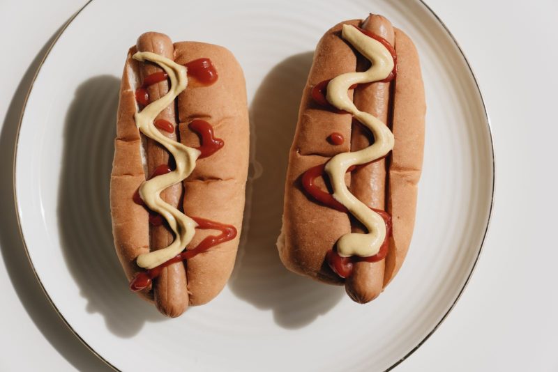 Deux hot-dogs nappés de ketchup et de moutarde
