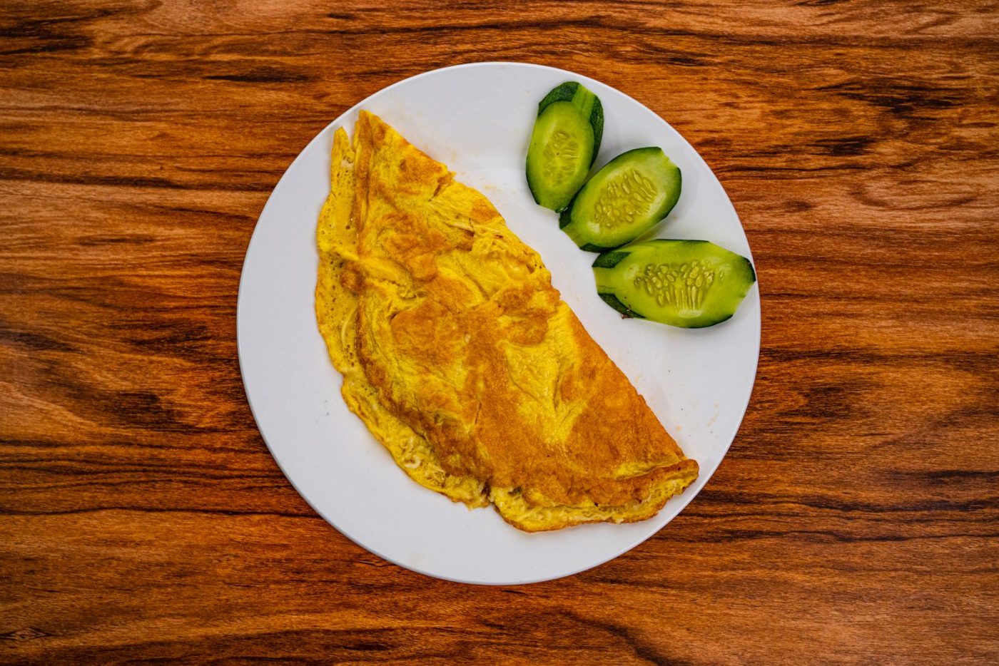 Omelette pliée et rondelles de concombre sur une assiette