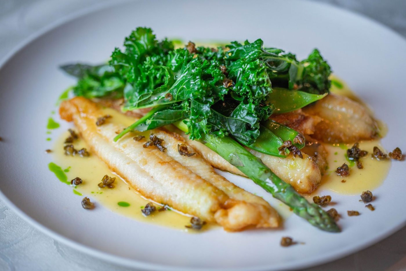 Filets de poisson poêlés au beurre, chou kale et asperges