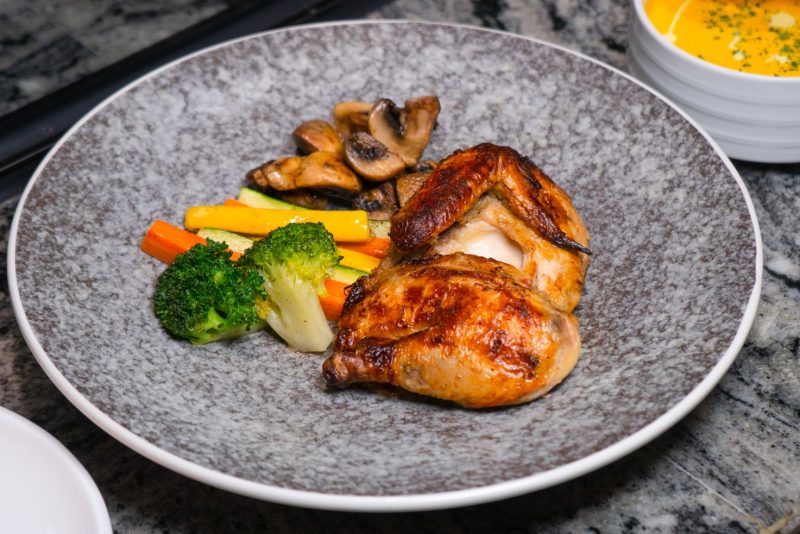 Assiette grise garnie de poulet doré, de brocolis, de carottes et de champignons